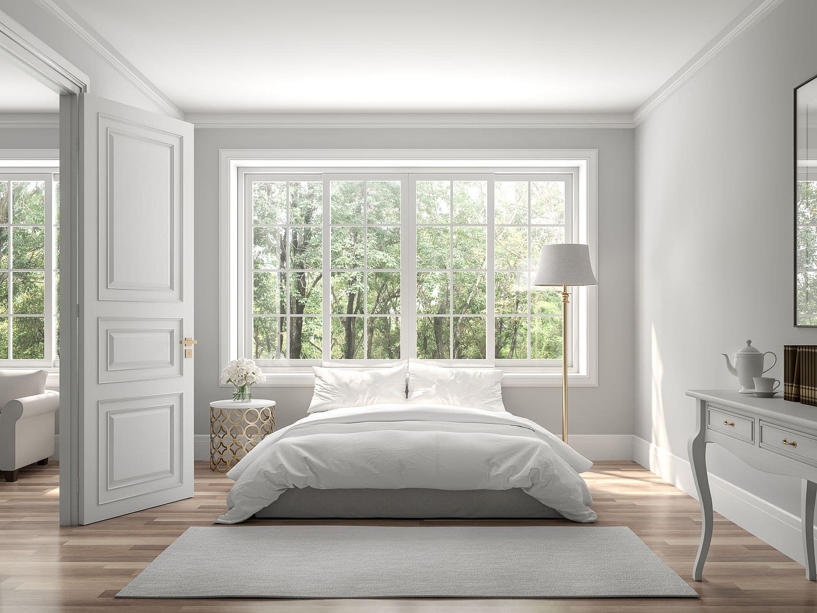 A gray bedroom with large double-hung windows.