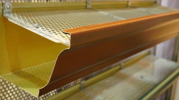 A close-up cross-section of a leafless gutter with a gutter guard.