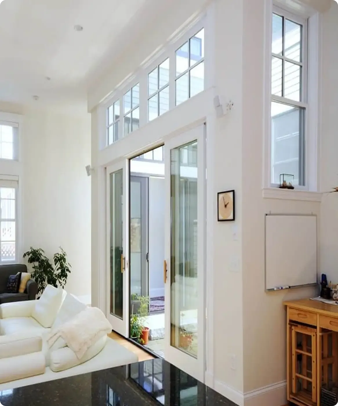 A white living room with sliding glass doors that open to an interior courtyard.