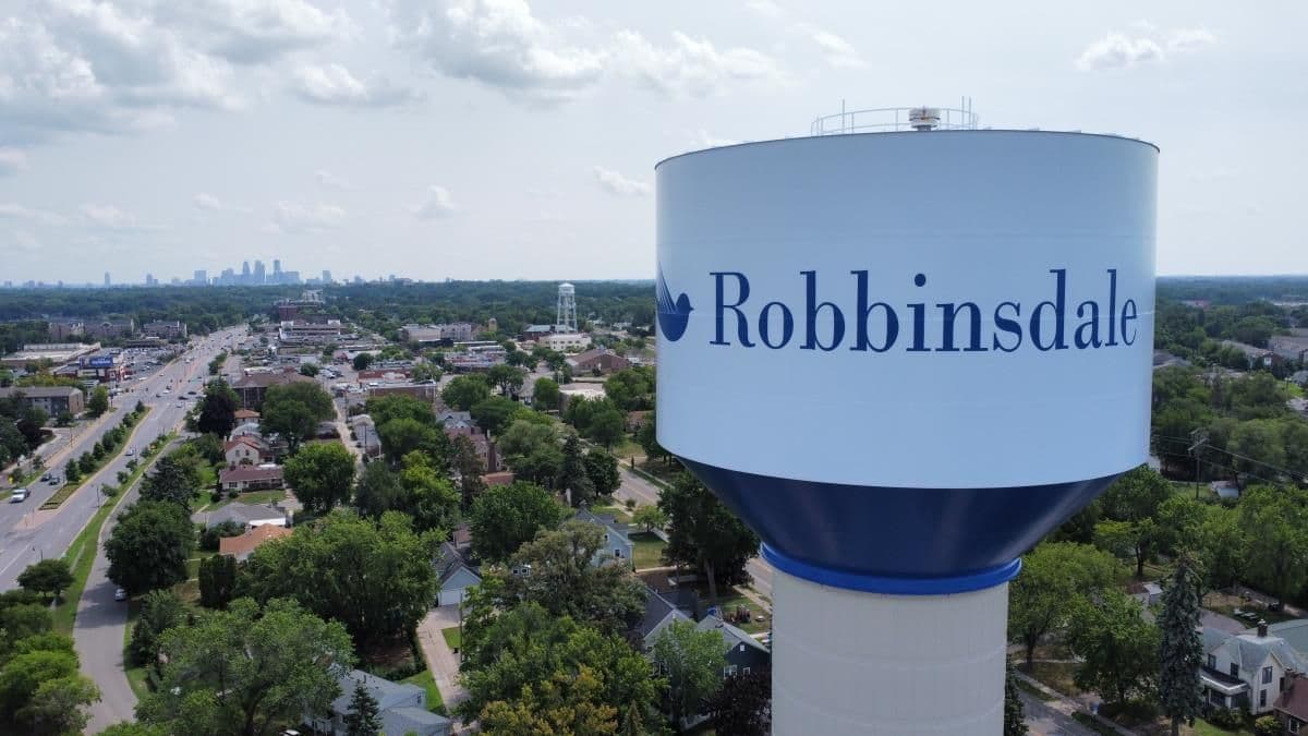 Aerial view of Robbinsdale, Minnesota, showing tree-lined neighborhoods and the West Broadway downtown district.